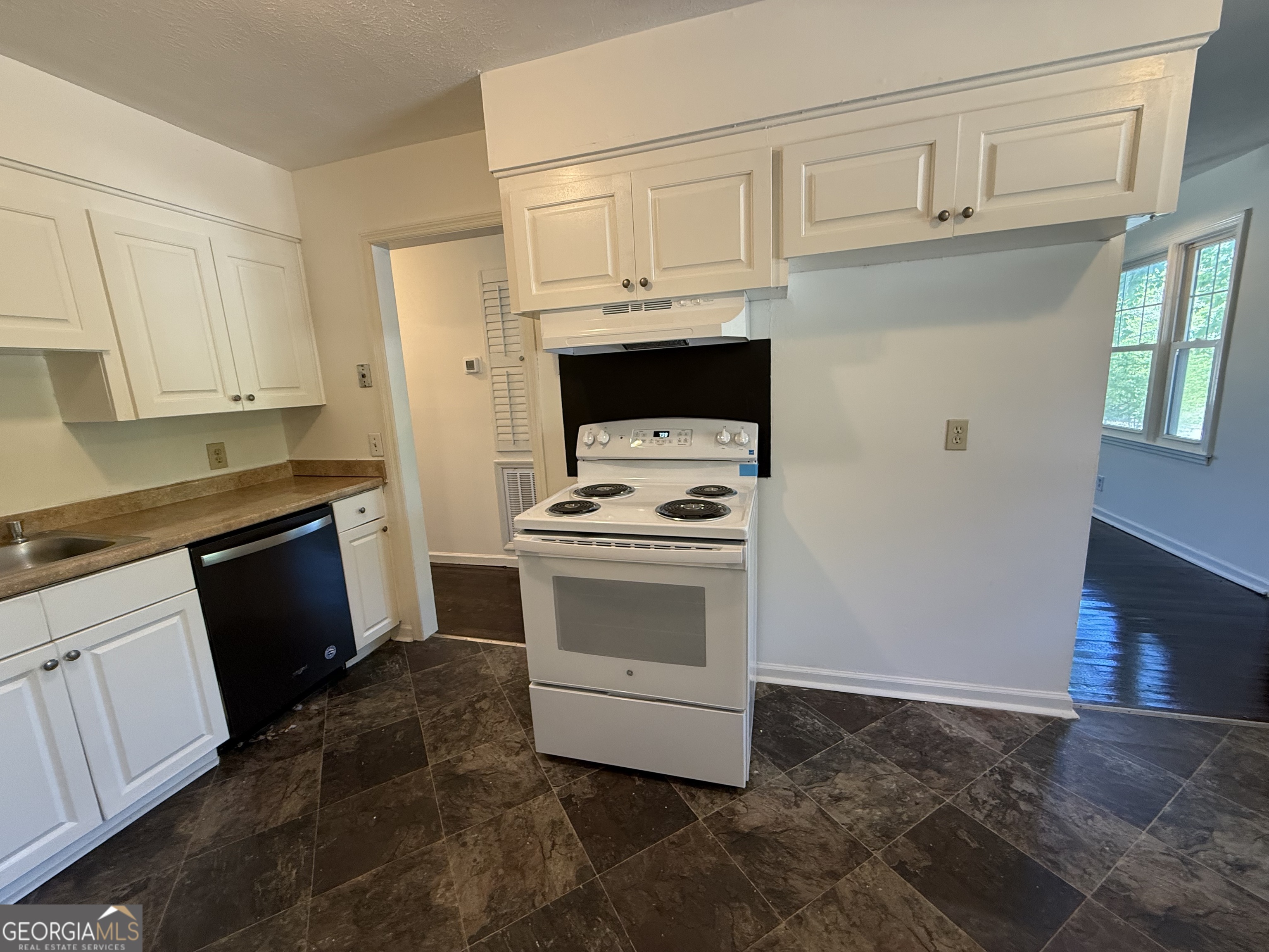 179 Youngs Mill Road LaGrange, GA 30241 - Photo 11 of 30 a kitchen with granite countertop white cabinets and stainless steel appliances