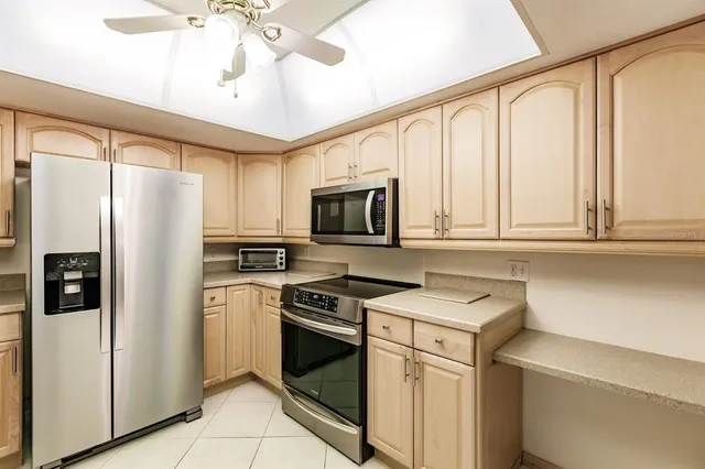a kitchen with stainless steel appliances white cabinets and a refrigerator