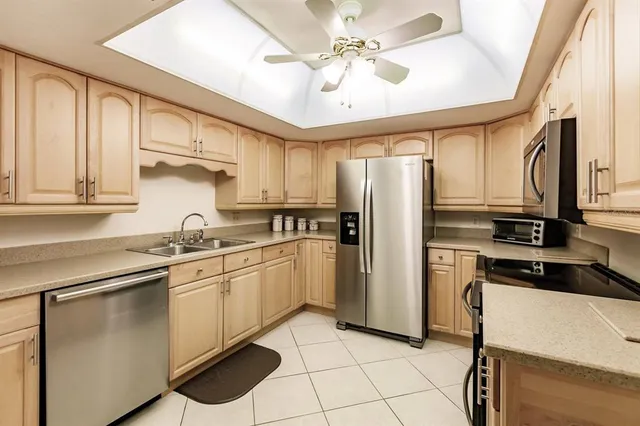 a kitchen with stainless steel appliances a refrigerator sink and cabinets