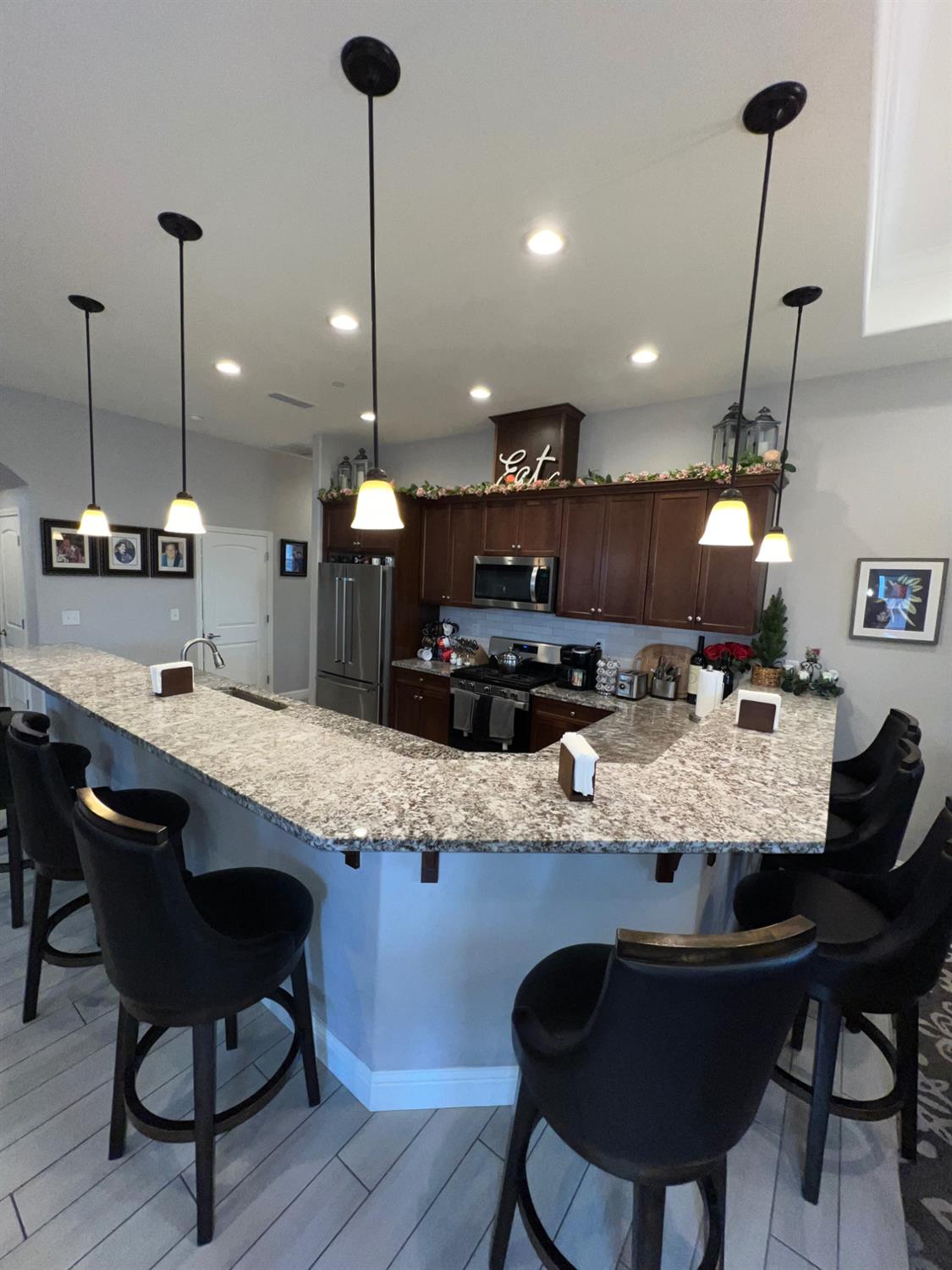889 Coloma Place Madera, CA 93637 - Photo 12 of 61 a kitchen with granite countertop a table chairs sink and wooden floor