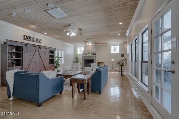 a spacious bedroom with a bed a dresser and a chandelier