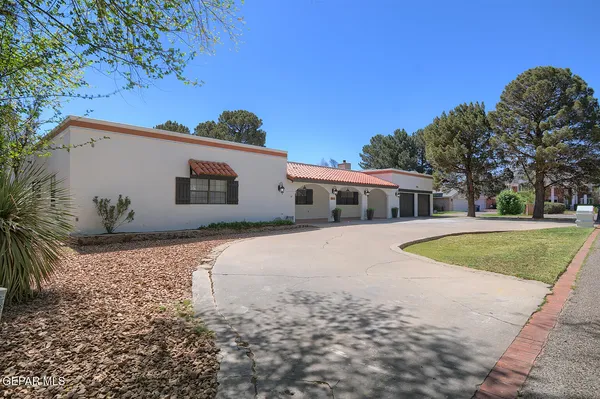 a front view of a house with a yard and trees