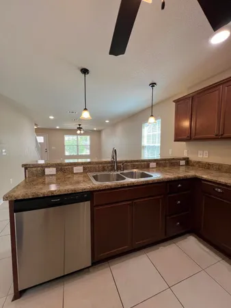 a kitchen with kitchen island granite countertop stainless steel appliances a sink and wooden cabinets