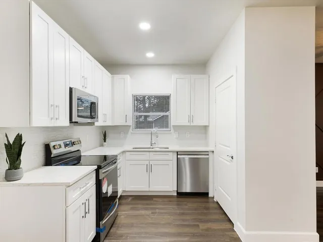 a kitchen with a sink a stove and cabinets