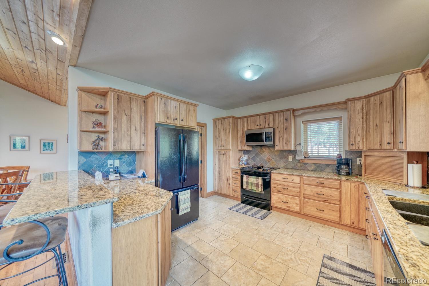 30800 West Ridge Road Buena Vista, CO 81211 - Photo 12 of 49 a kitchen with stainless steel appliances kitchen island granite countertop a refrigerator and stove top oven