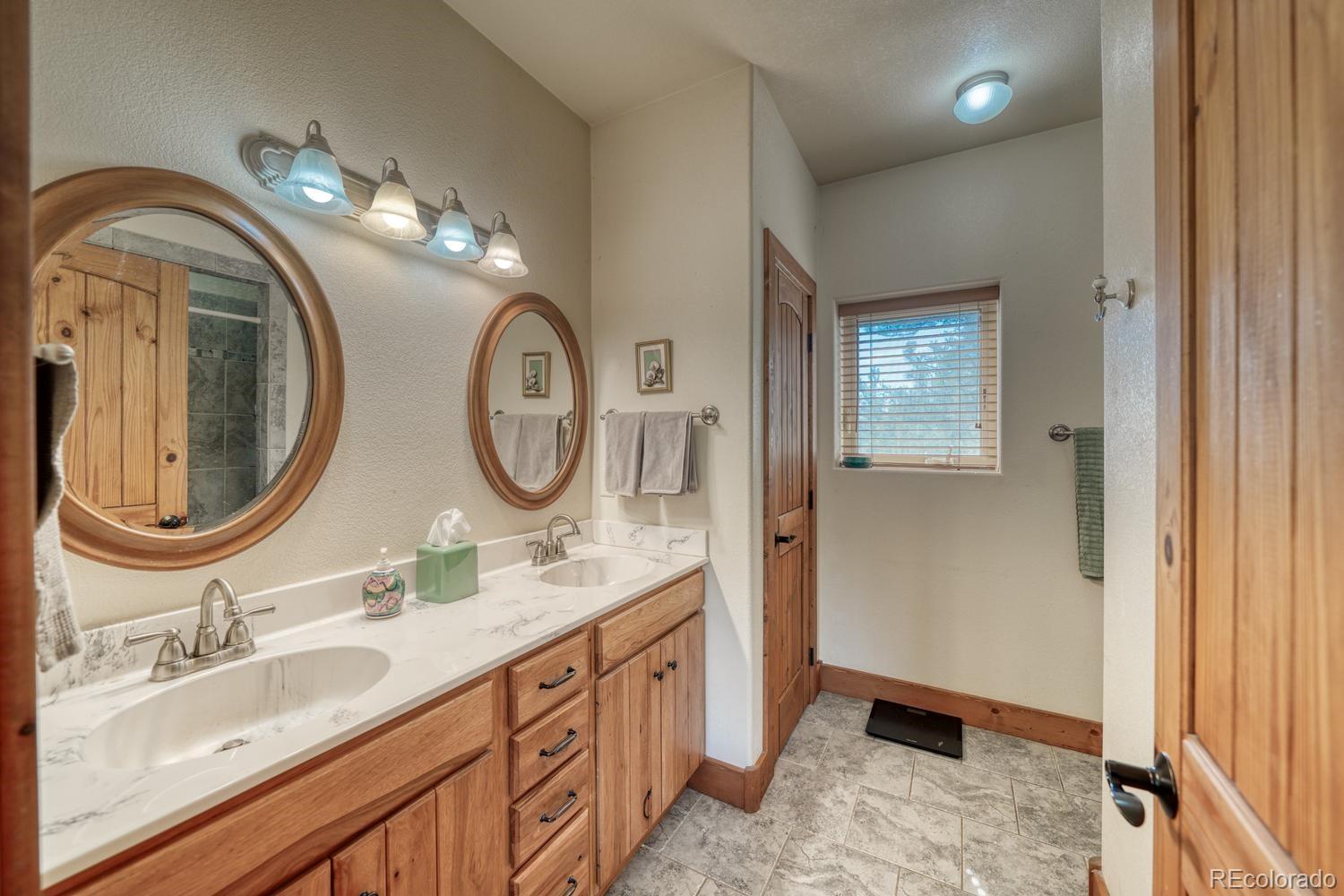 30800 West Ridge Road Buena Vista, CO 81211 - Photo 19 of 49 a bathroom with a granite countertop double vanity sink and a mirror