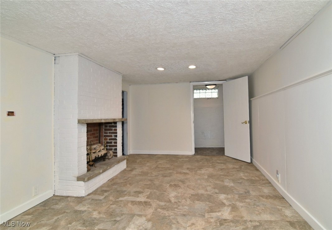 1443 Churchill Road Lyndhurst, OH 44124 - Photo 26 of 39 Unfurnished living room featuring a fireplace and a textured ceiling
