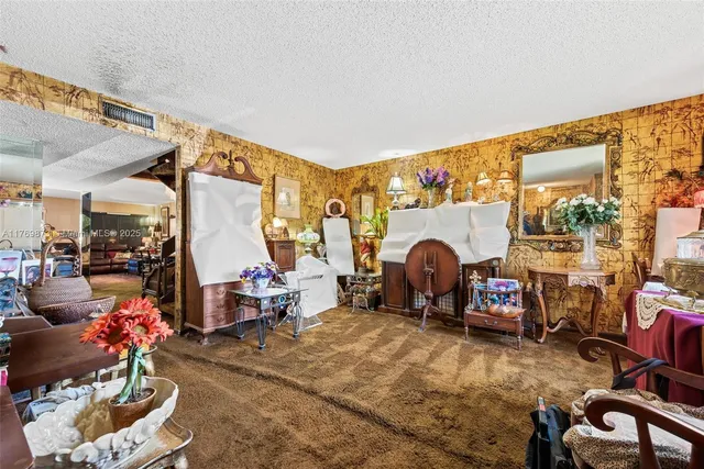 a living room with furniture a fireplace and a floor to ceiling window