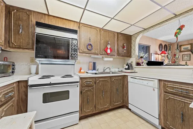 a kitchen with granite countertop cabinets stainless steel appliances and a counter space