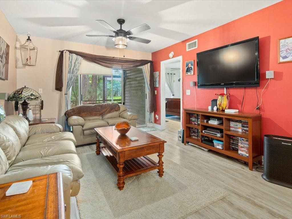 1965 Courtyard Way, Unit E106 Naples, FL 34112 - Photo 8 of 21 a living room with furniture and a flat screen tv