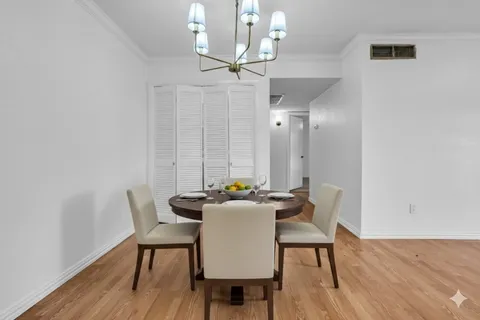 a dining room with furniture wooden floor a rug and a chandelier