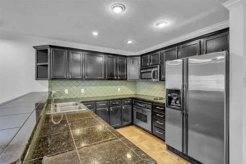 a kitchen with stainless steel appliances granite countertop a refrigerator and a sink