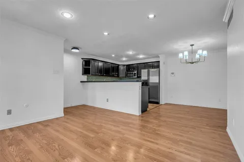 a view of a kitchen with a refrigerator and a stove top oven