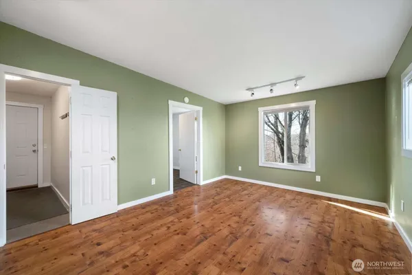 a dining room with wooden floor a chandelier fan a wooden table and chairs
