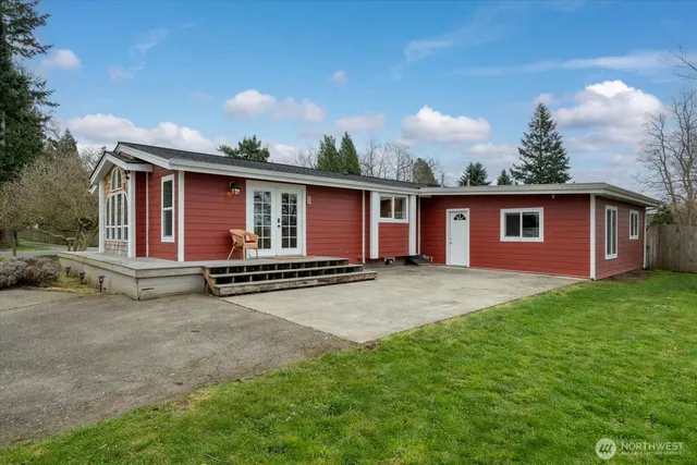 a view of a house with backyard and a tree
