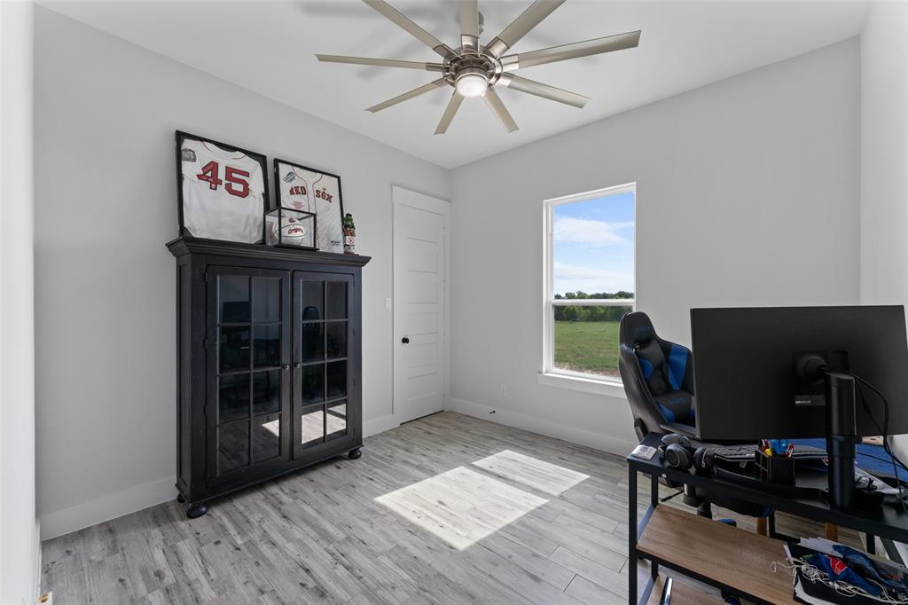 4411 Fm 751 Wills Point Wills Point, TX 75169 - Photo 31 of 40 Room featuring wood-finish flooring, a contemporary ceiling fan with integrated lighting, and light gray wall finishes
