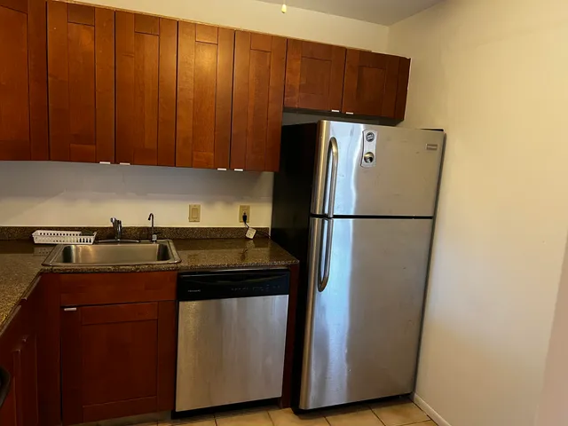 a kitchen with a refrigerator a stove and wooden cabinets