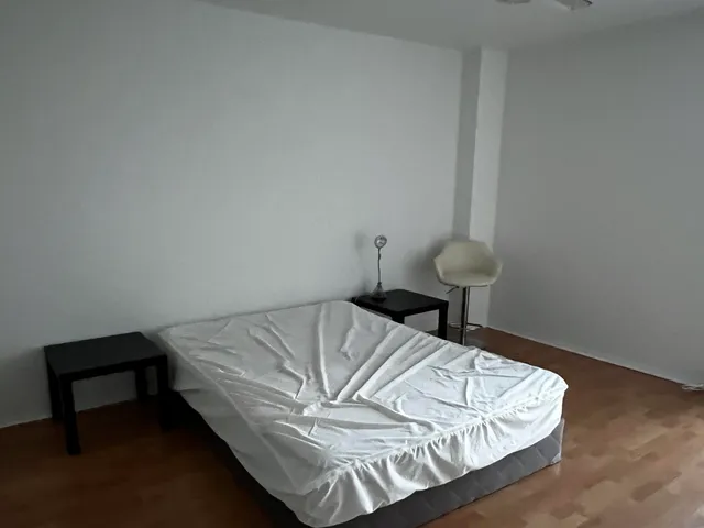 a bed sitting in a bedroom next to a window