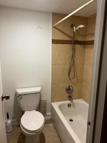 a white toilet sitting next to a bath tub