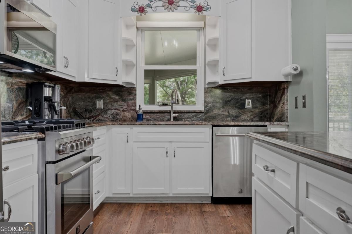 609 Morgan Street Albany, GA 31705 - Photo 12 of 74 a kitchen with granite countertop white cabinets and white appliances