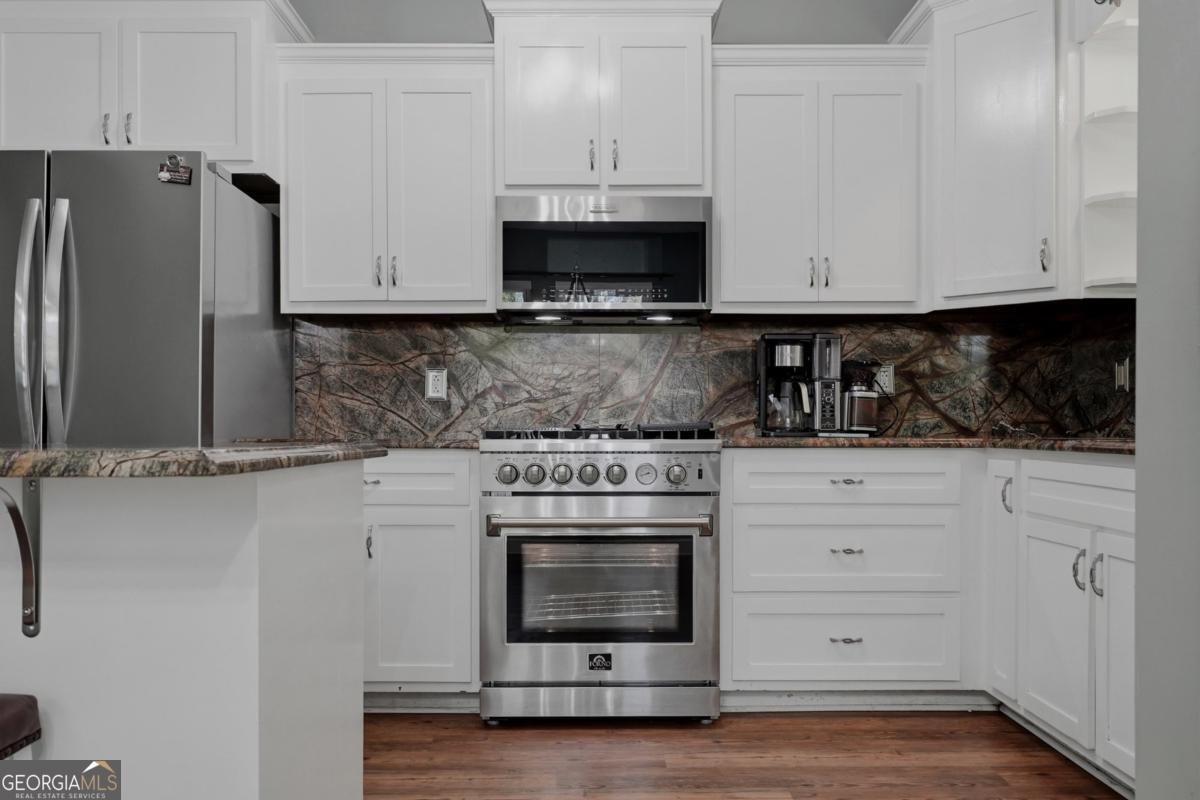 609 Morgan Street Albany, GA 31705 - Photo 14 of 74 a kitchen with white cabinets and stainless steel appliances