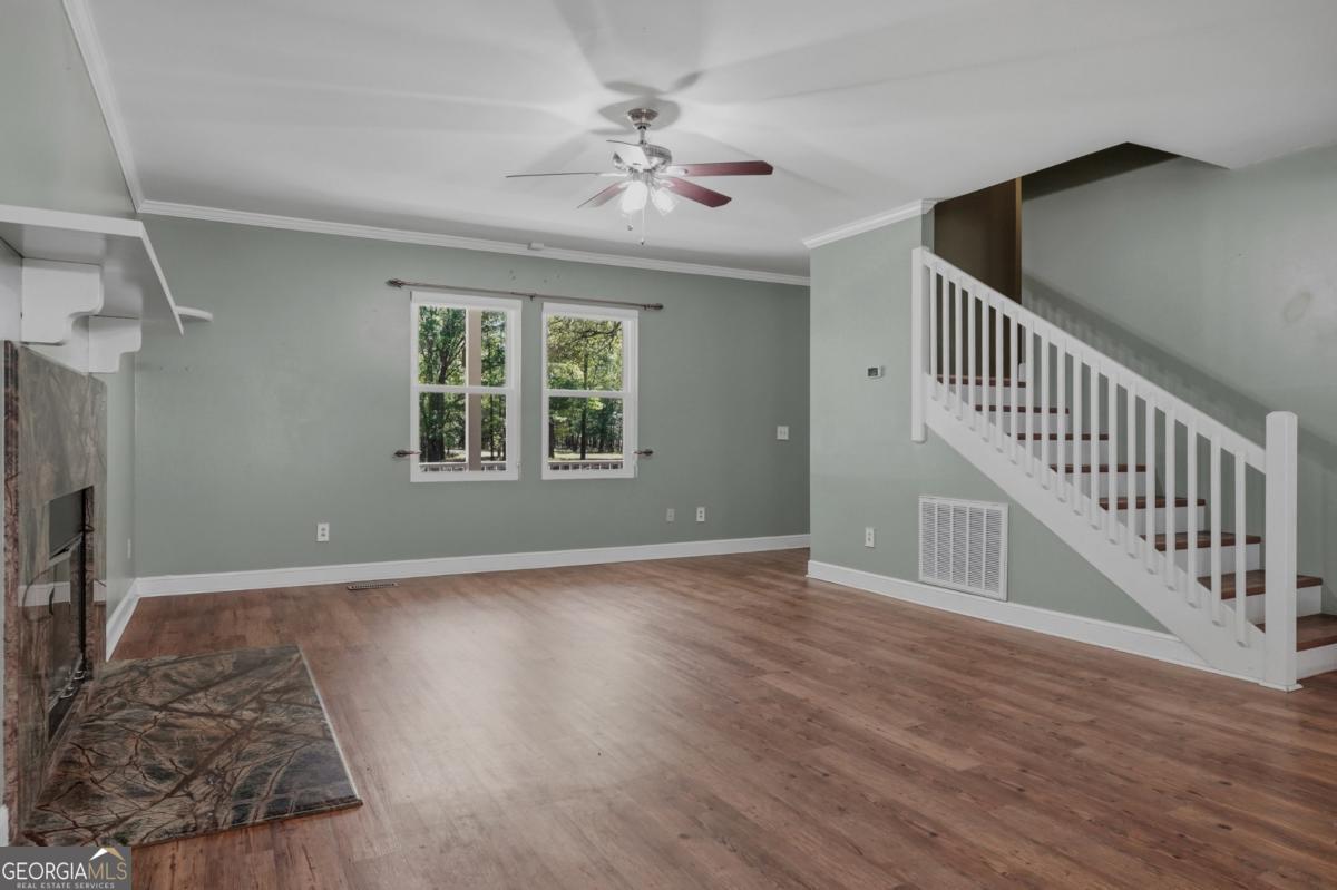 609 Morgan Street Albany, GA 31705 - Photo 6 of 74 a view of an empty room with wooden floor floors and a ceiling fan