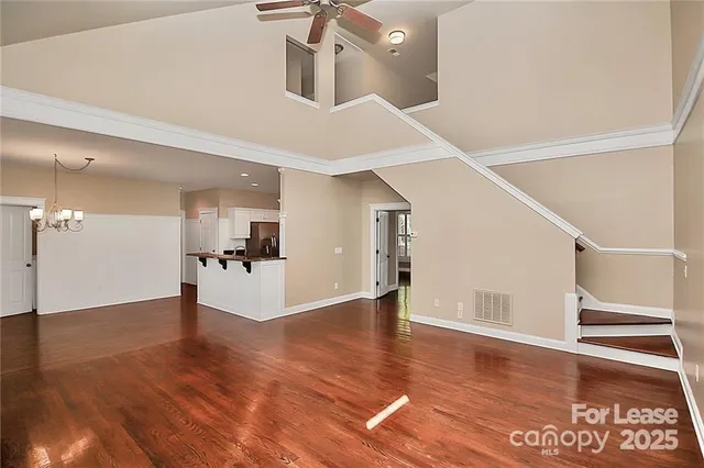 a view of a hallway with wooden floor and a living room