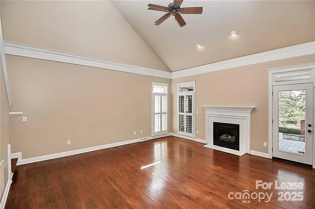 a view of empty room with wooden floor and fireplace