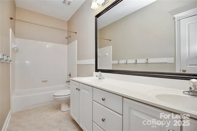 a bathroom with a granite countertop sink a toilet and shower