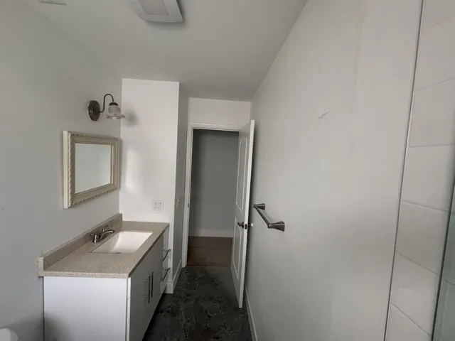 a bathroom with a granite countertop sink mirror vanity and toilet