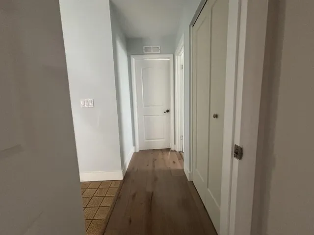 a view of an empty room with wooden floor