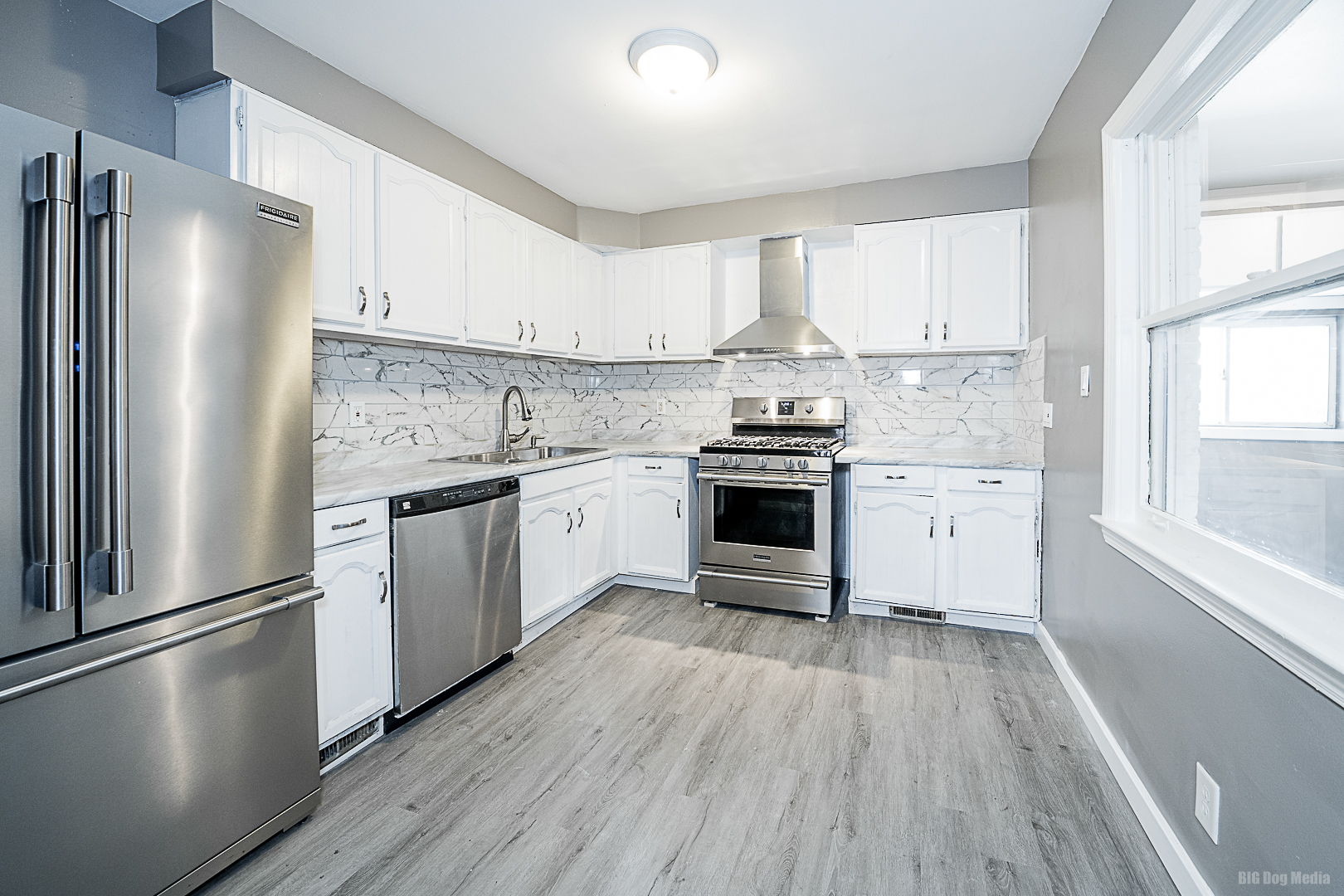11 167th Street Calumet City, IL 60409 - Photo 8 of 20 a kitchen with stainless steel appliances granite countertop a stove a sink dishwasher a refrigerator and white cabinets with wooden floor