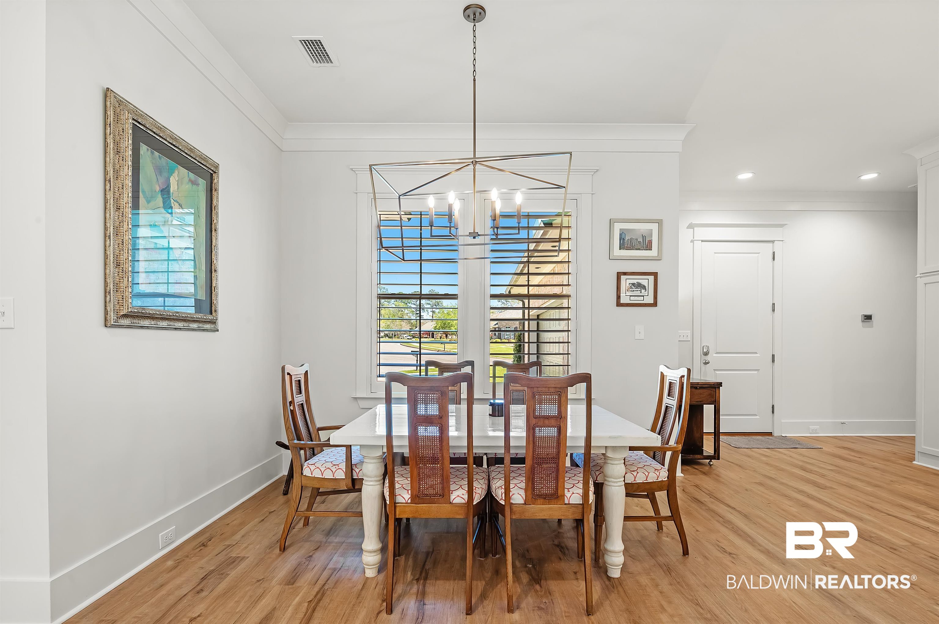 27888 Oakachoy Loop Daphne, AL 36526 - Photo 20 of 65 Dining space with light wood finished floors, visible vents, ornamental molding, and a chandelier