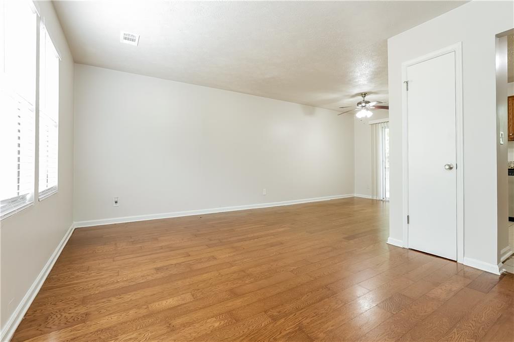 3352 Herrenhut Road Lithonia, GA 30038 - Photo 4 of 27 an empty room with wooden floor and windows