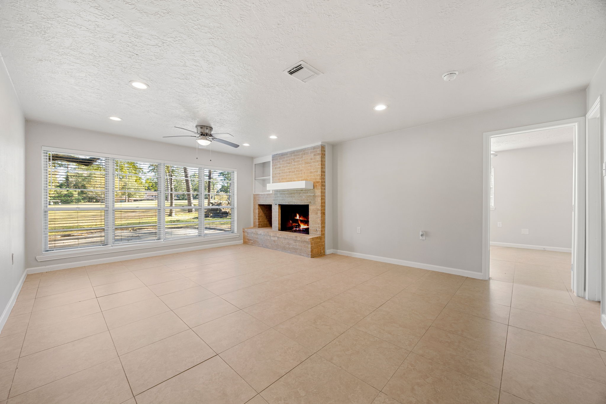 479 Brandon Road Conroe, TX 77302 - Photo 14 of 42 a view of an empty room with a fireplace and a window