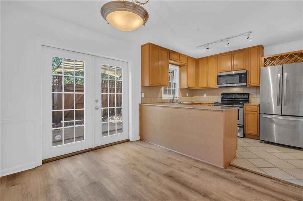 1101 Collier Road Northwest, Unit I2 Atlanta, GA 30318 - Photo 3 of 14 a kitchen with stainless steel appliances granite countertop a refrigerator a stove a sink and a microwave