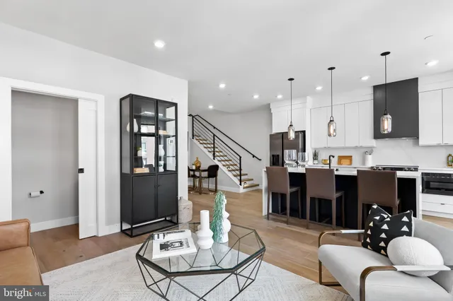 a living room with furniture kitchen view and a chandelier