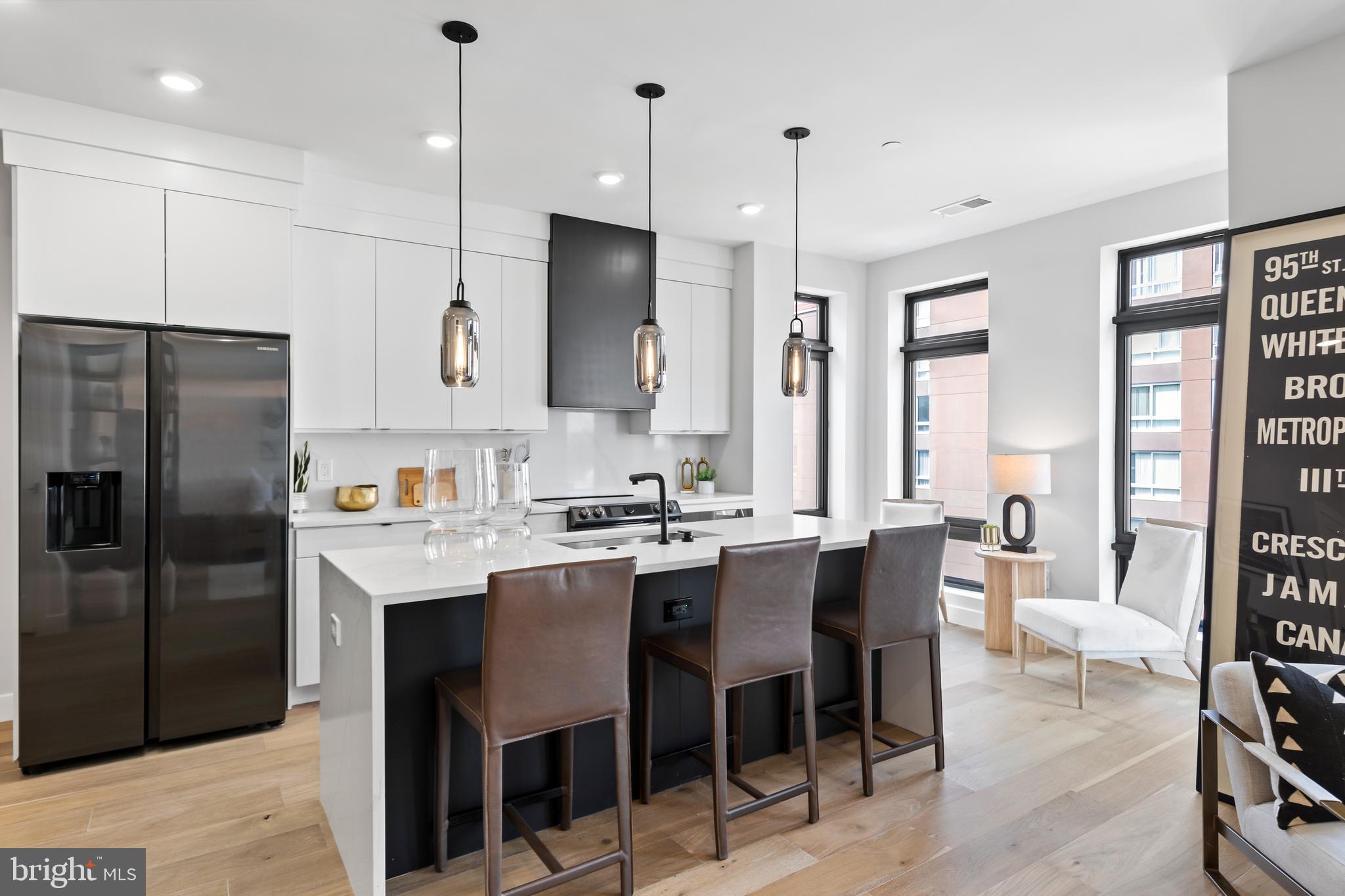 1208 M Street Northwest, Unit 61 Washington, DC 20005 - Photo 24 of 39 a kitchen with stainless steel appliances kitchen island granite countertop a table chairs and a refrigerator