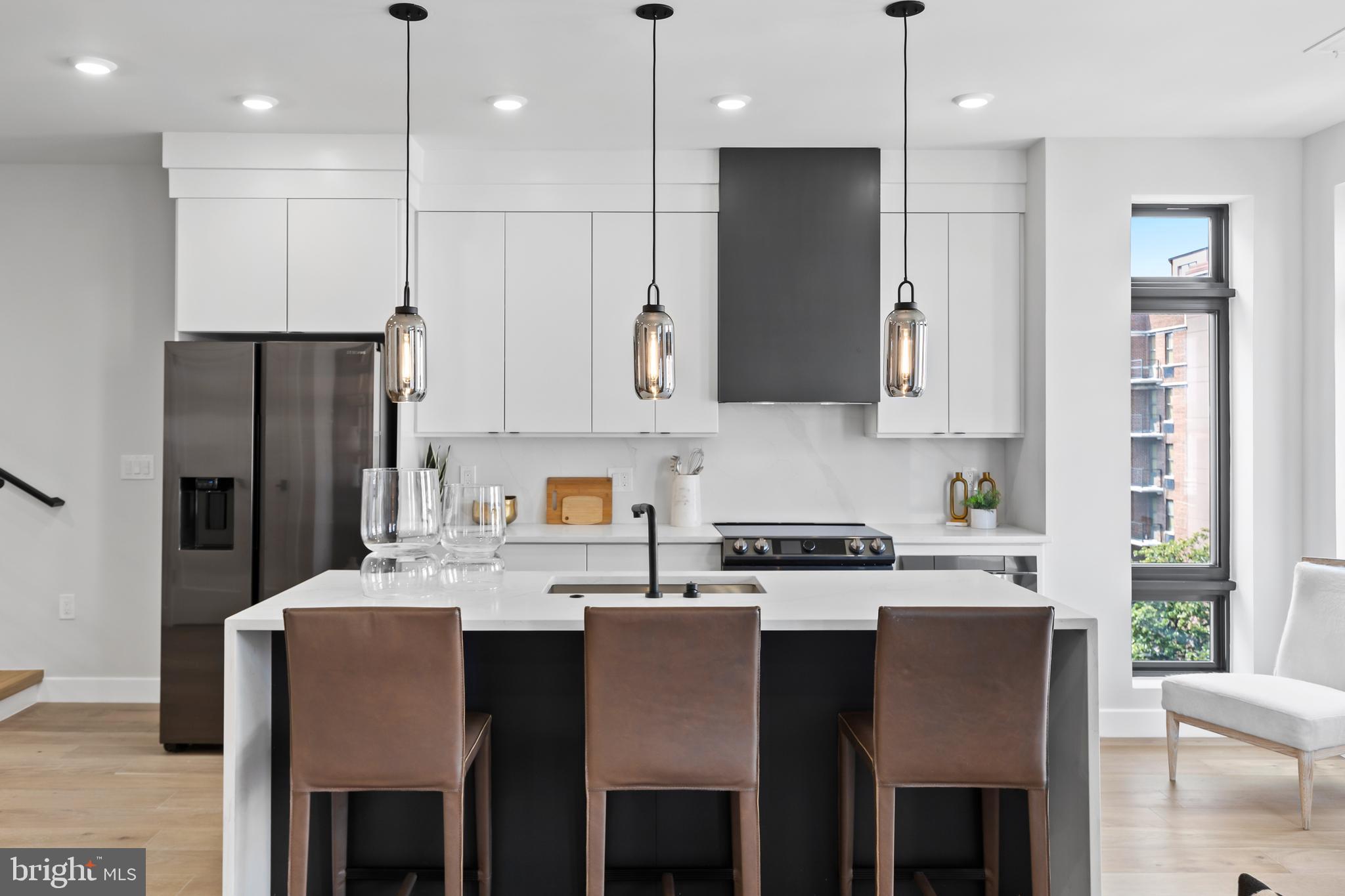 1208 M Street Northwest, Unit 61 Washington, DC 20005 - Photo 6 of 39 a kitchen with stainless steel appliances granite countertop a dining table chairs refrigerator and sink