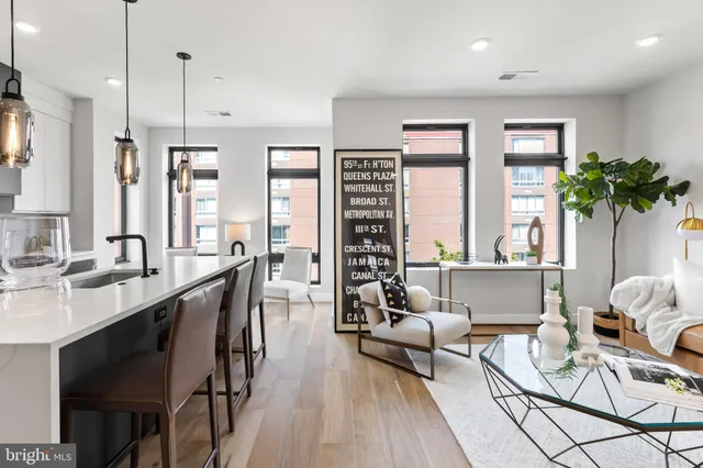 a living room with furniture a large window and a potted plant