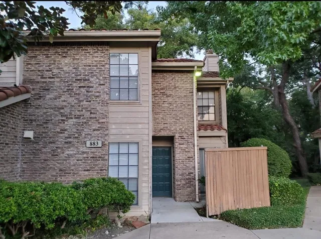 front view of a house with a brick wall