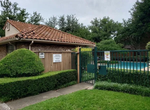 a view of a house with a small yard plants and large tree