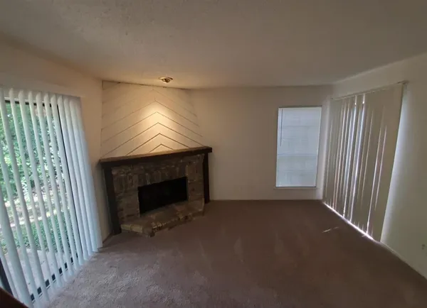 a view of empty room with fireplace and windows