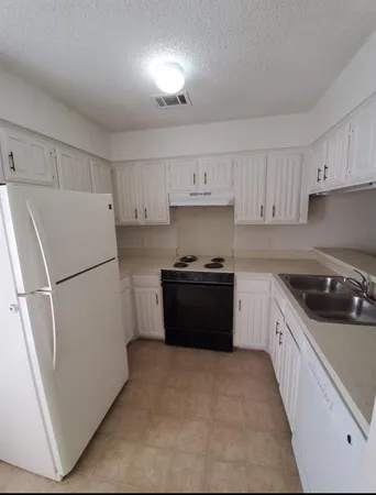 a kitchen with a refrigerator sink and stove