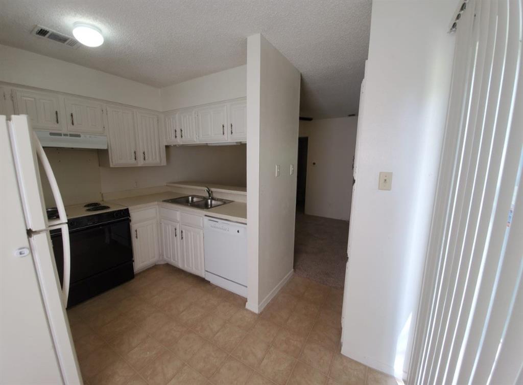 883 Waterfall Way Richardson, TX 75080 - Photo 9 of 26 a kitchen with a refrigerator stove and white cabinets