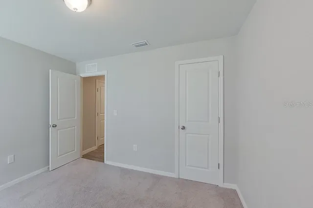 a view of an empty room and closet area