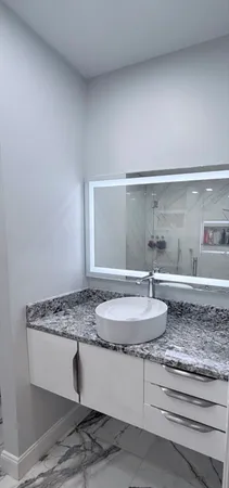 a bathroom with a granite countertop sink and a mirror