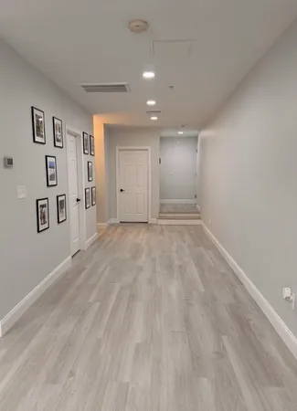 a view of a big room with wooden floor and windows