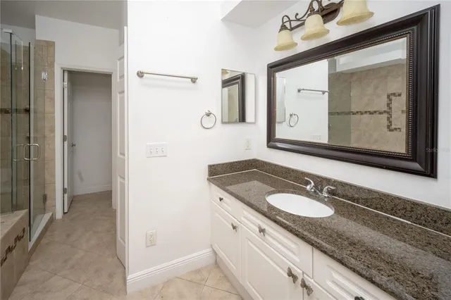 a bathroom with a granite countertop sink mirror and vanity