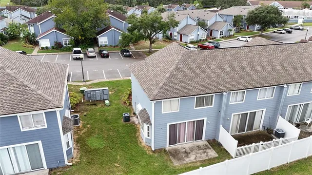 an aerial view of residential houses with outdoor space and parking